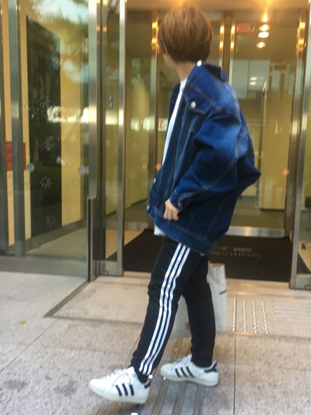 ブルー系のデニムジャケット、ホワイト系のTシャツ/カットソー、ブラック系のその他パンツを着用したレディースの春コーディネートの1枚目の写真