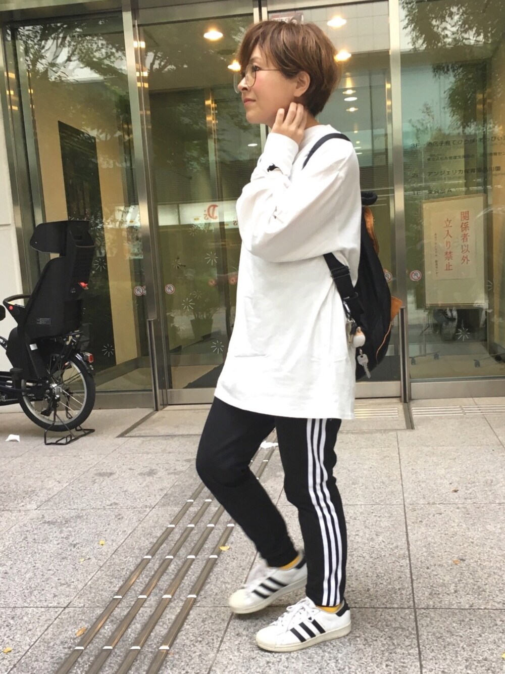 ホワイト系のTシャツ/カットソー、ブラック系のその他パンツ、ホワイト系のスニーカーを着用したレディースの春コーディネートの1枚目の写真