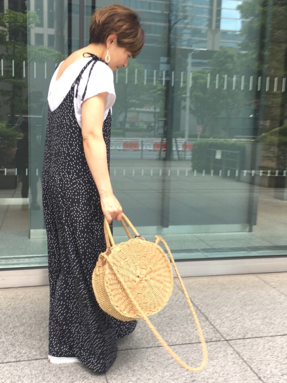 ホワイト系のTシャツ/カットソー、ブラック系のサロペット/オーバーオール、ブラック系のスニーカーを着用したレディースの春コーディネートの1枚目の写真