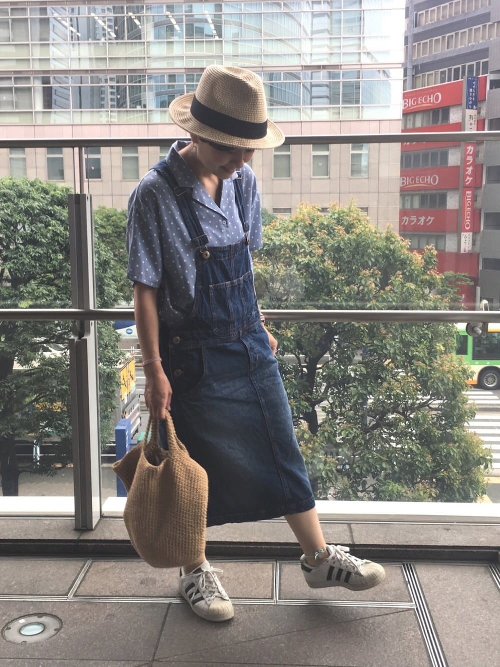 ブルー系のシャツ/ブラウス、ブルー系のサロペット/オーバーオール、ホワイト系のスニーカーを着用したレディースの夏コーディネートの1枚目の写真