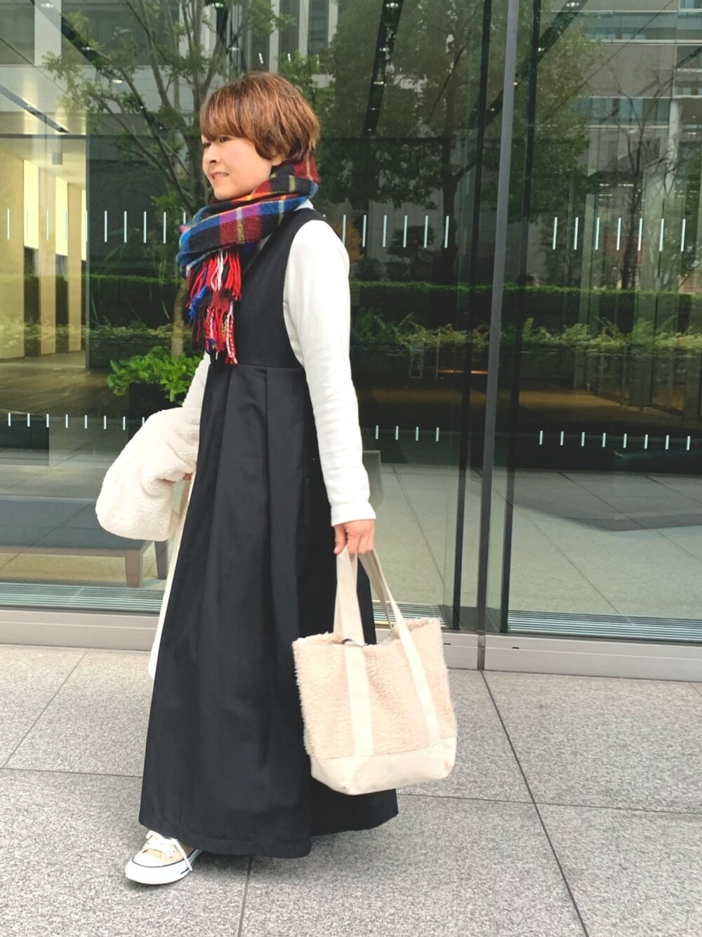 ブラック系のワンピース、ベージュ系のスニーカー、ホワイト系のブルゾンを着用したレディースの冬コーディネートの1枚目の写真