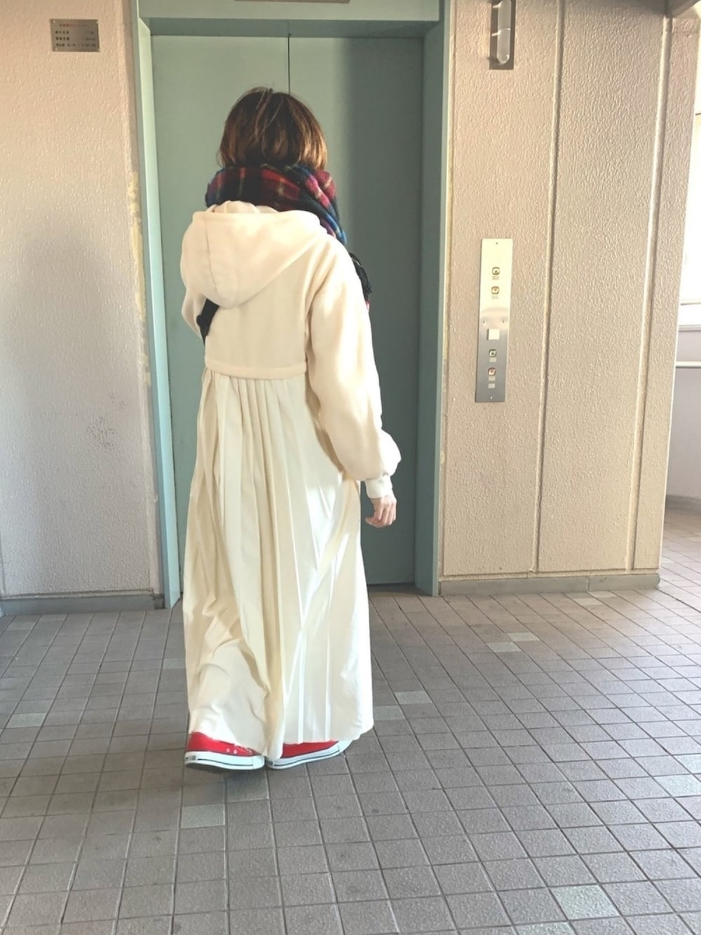 ホワイト系のワンピース、レッド系のスニーカー、ホワイト系のボディバッグ/ウエストポーチを着用したレディースの冬コーディネートの1枚目の写真