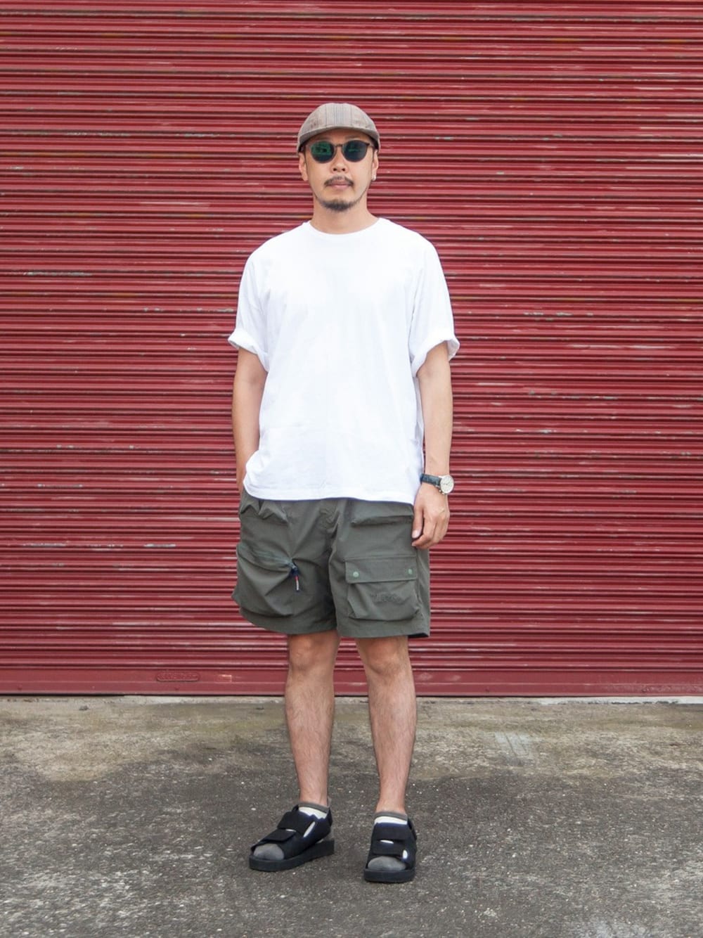 ホワイト系のTシャツ/カットソー、グリーン系のその他パンツ、ブラック系のサンダルを着用したメンズの夏コーディネートの1枚目の写真