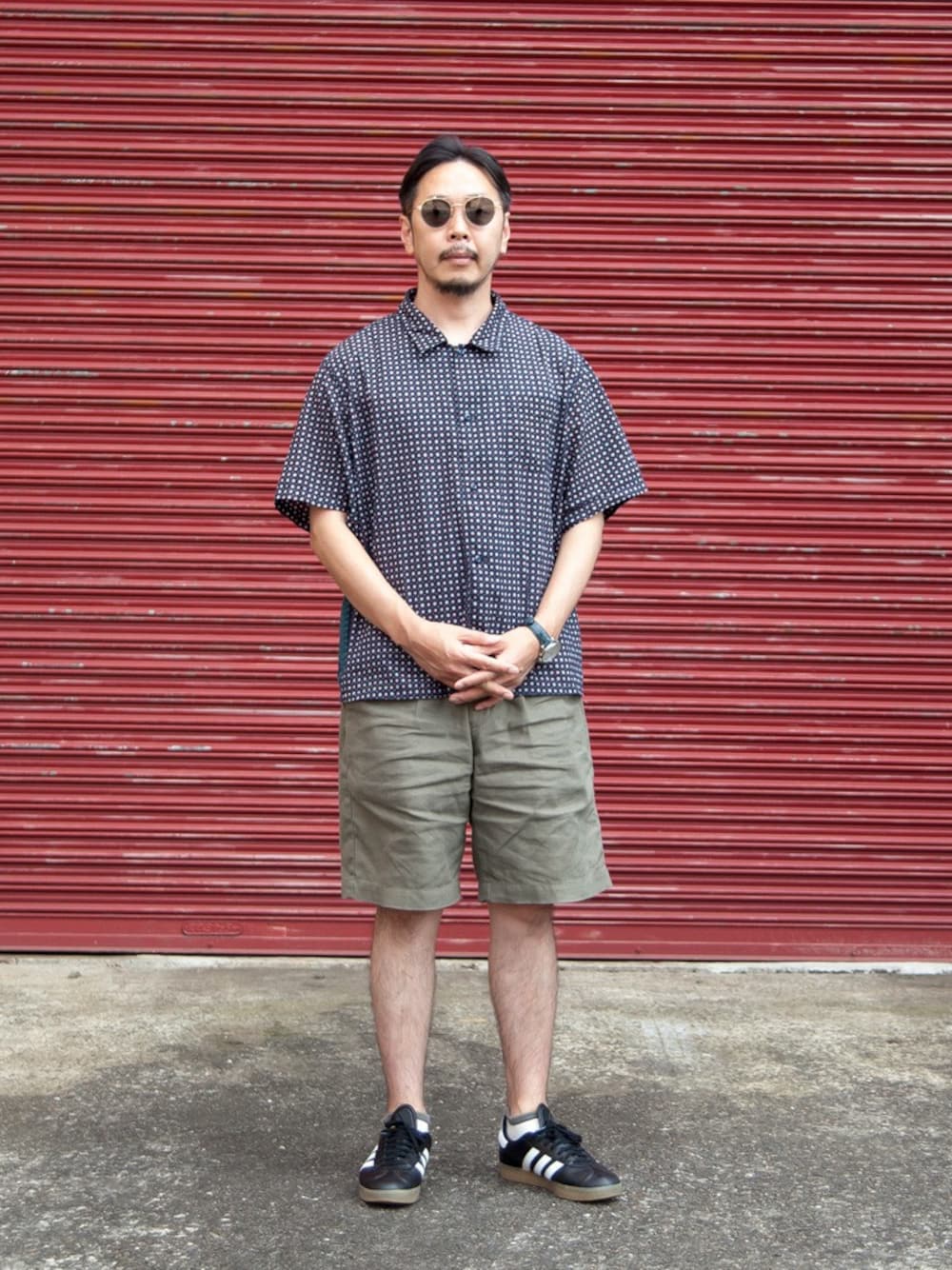 ブルー系のシャツ/ブラウス、グリーン系のその他パンツ、ゴールド系のサングラスを着用したメンズの夏コーディネートの1枚目の写真