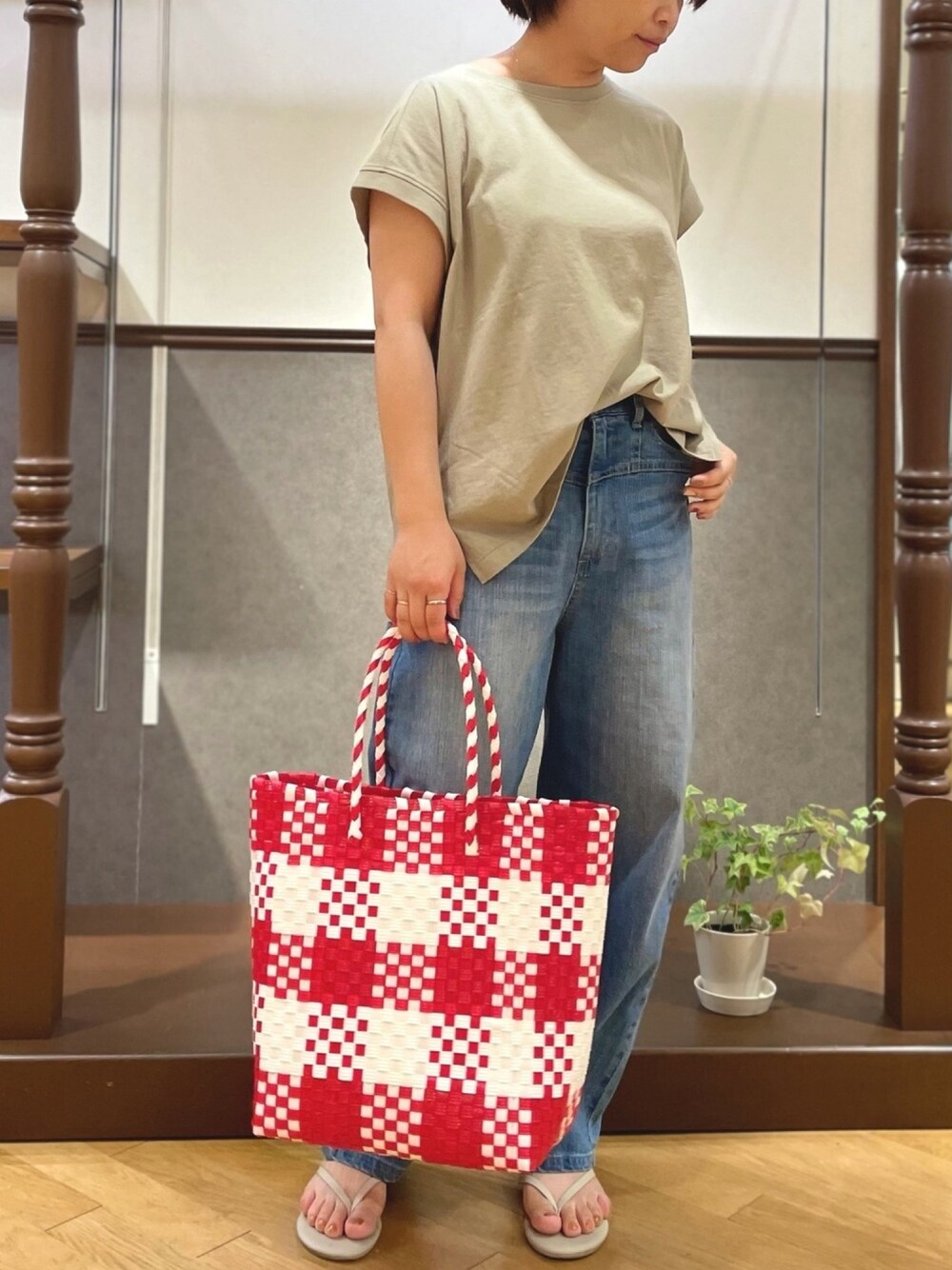 グリーン系のTシャツ/カットソー、ブルー系のデニムパンツ、レッド系のかごバッグを着用したレディースの春コーディネートの1枚目の写真