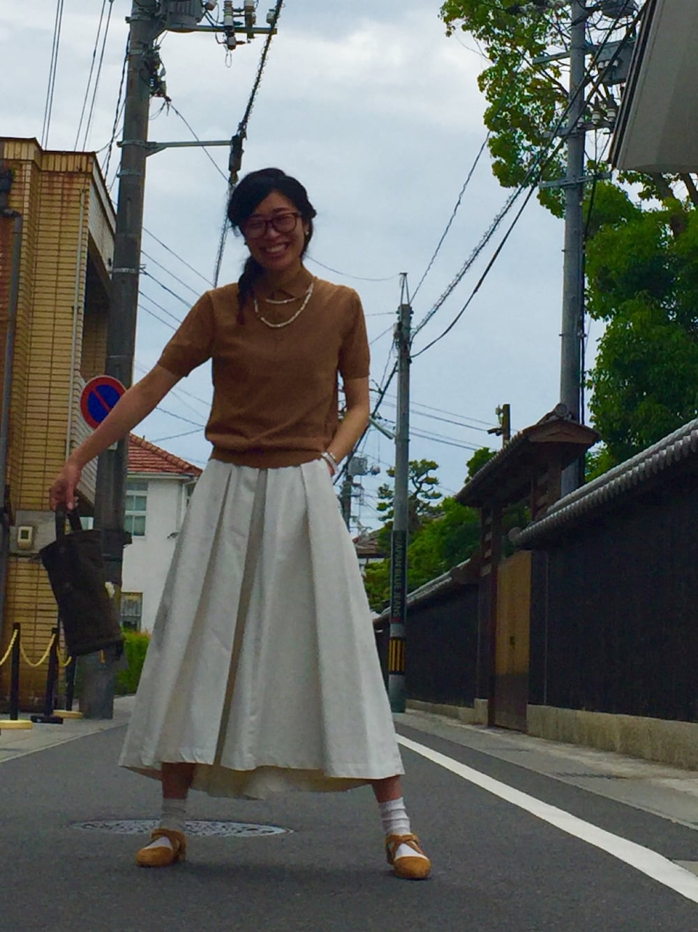 ホワイト系のスカート、グリーン系のトートバッグを着用したレディースの夏コーディネートの1枚目の写真