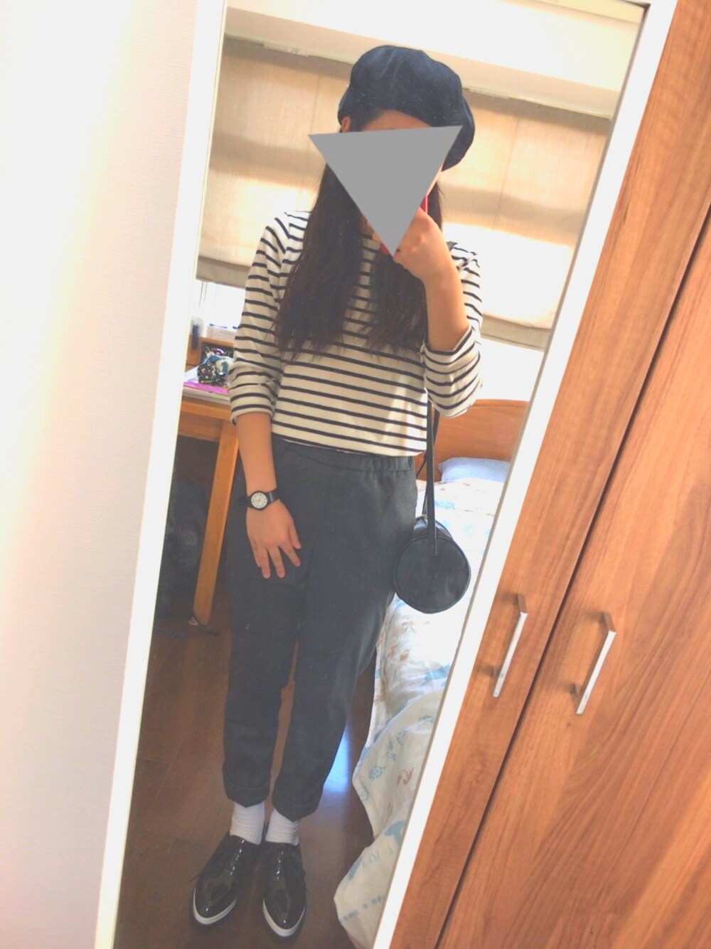 グレー系のパンツ、ブラック系のショルダーバッグ、ブラック系のドレスシューズを着用したレディースの秋コーディネートの1枚目の写真