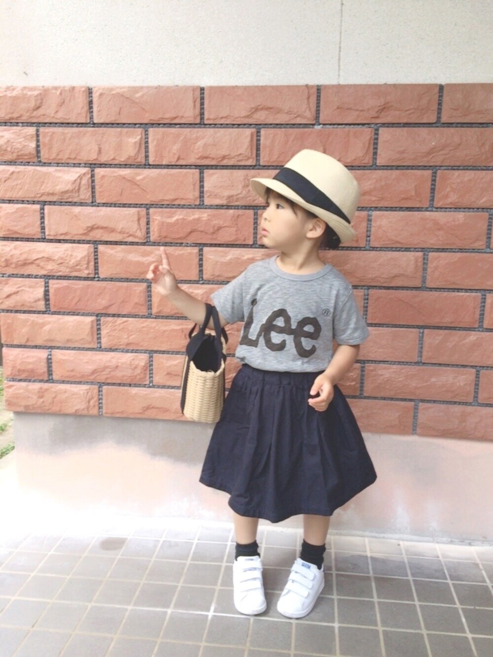 グレー系のTシャツ/カットソー、ブルー系のスカート、ホワイト系のスニーカーを着用したキッズの夏コーディネートの1枚目の写真