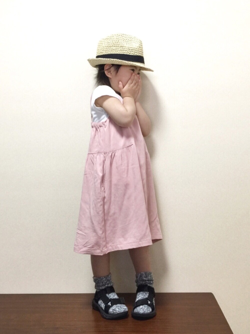 ブラック系のTシャツ/カットソー、ピンク系のワンピース、ブラック系のサンダルを着用したキッズの春コーディネートの1枚目の写真