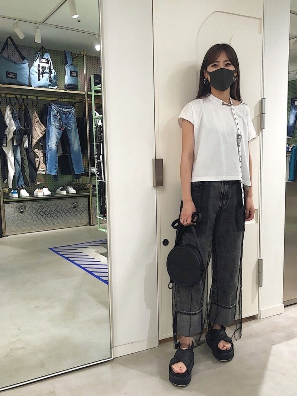 ホワイト系のTシャツ/カットソー、ブラック系のパンツ、ブラック系のサンダルを着用したレディースの春コーディネートの1枚目の写真