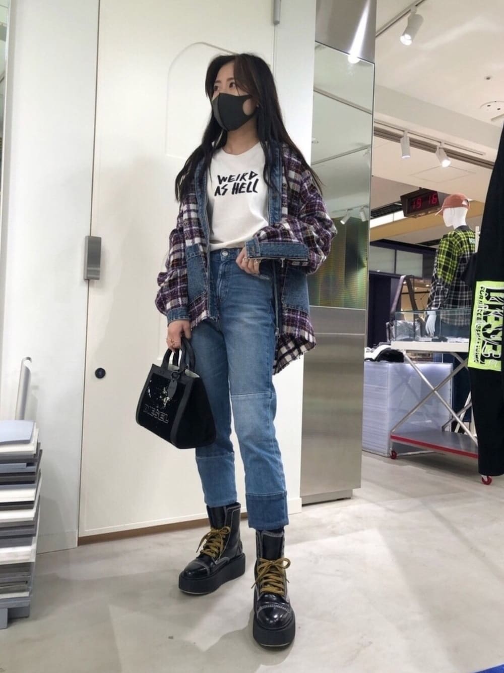 ブルー系のデニムパンツ、ブラック系のハンドバッグ、ホワイト系のTシャツ/カットソーを着用したレディースの秋コーディネートの1枚目の写真