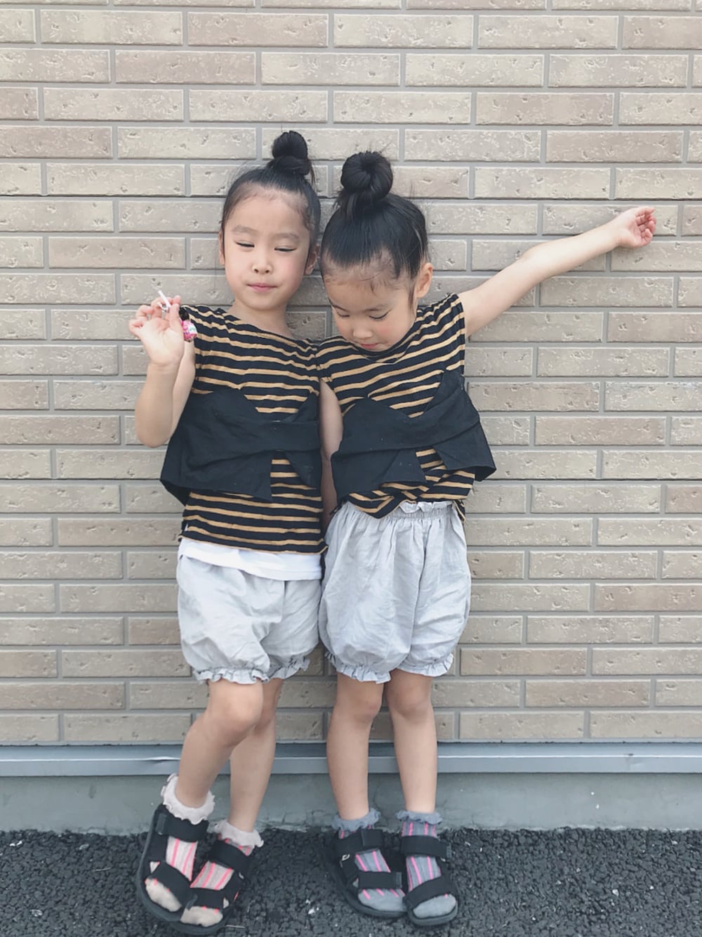 イエロー系のTシャツ/カットソー、ブラック系のサンダル、グレー系のパンツを着用したキッズの夏コーディネートの1枚目の写真