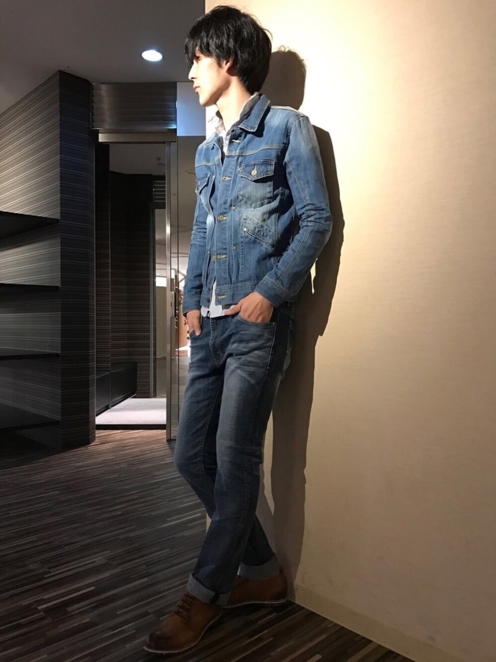 ブルー系のデニムジャケット、ブルー系のデニムパンツ、ブラウン系のブーツを着用したメンズの冬コーディネートの1枚目の写真