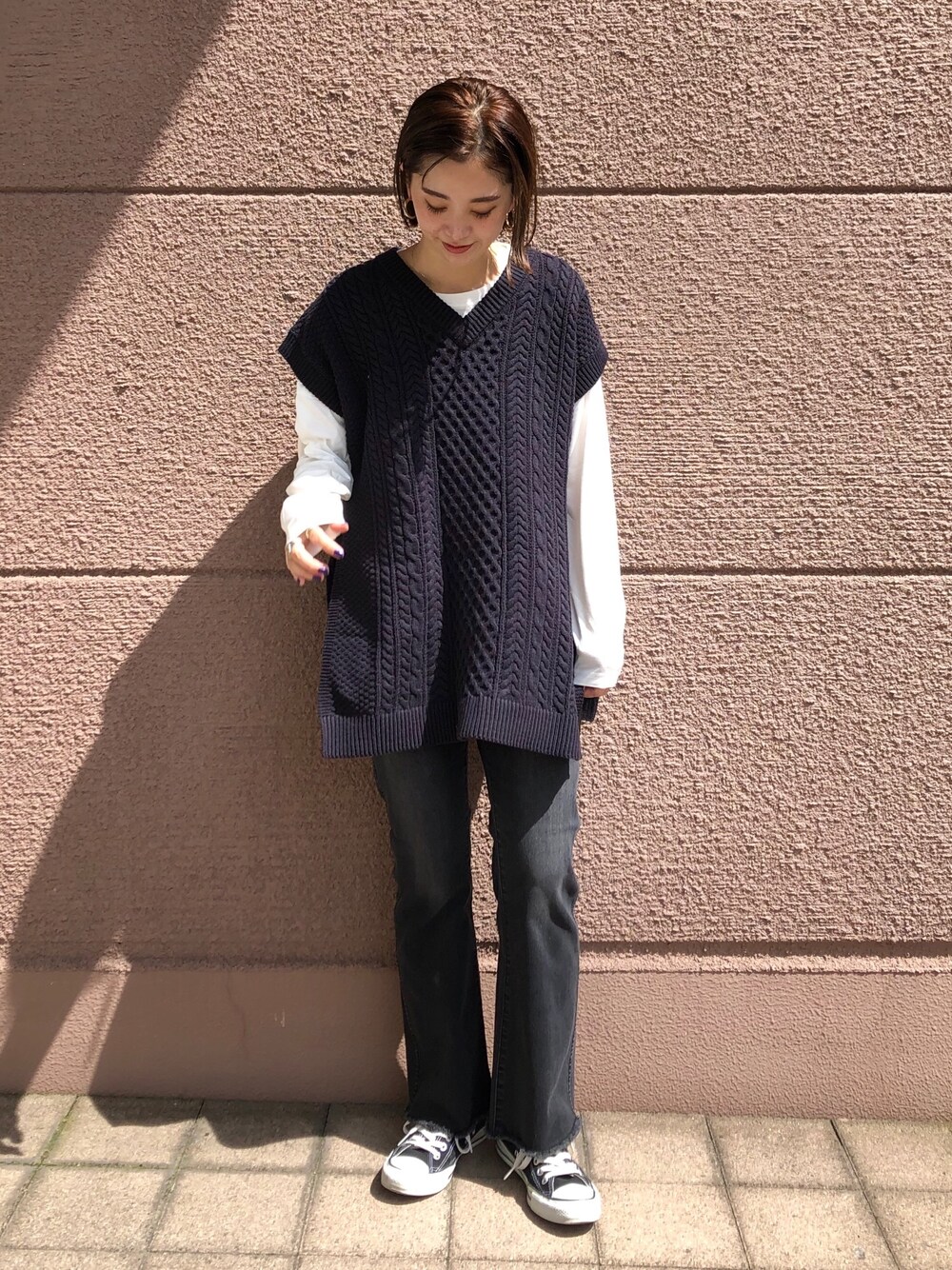 ブルー系のベスト、ホワイト系のTシャツ/カットソー、ブラック系のデニムパンツを着用したレディースの秋コーディネートの1枚目の写真