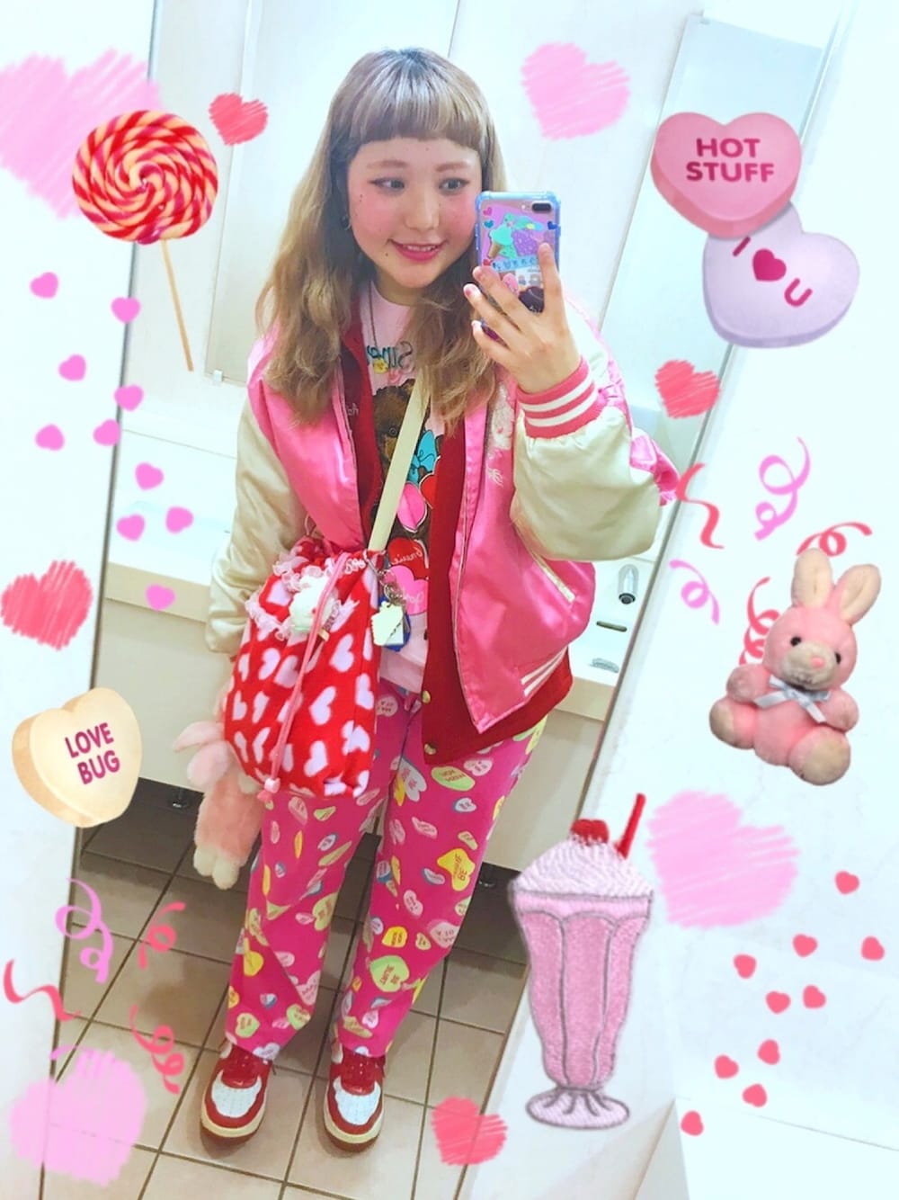 ピンク系のスカジャン、ピンク系のパンツ、レッド系のスニーカーを着用したレディースの冬コーディネートの1枚目の写真