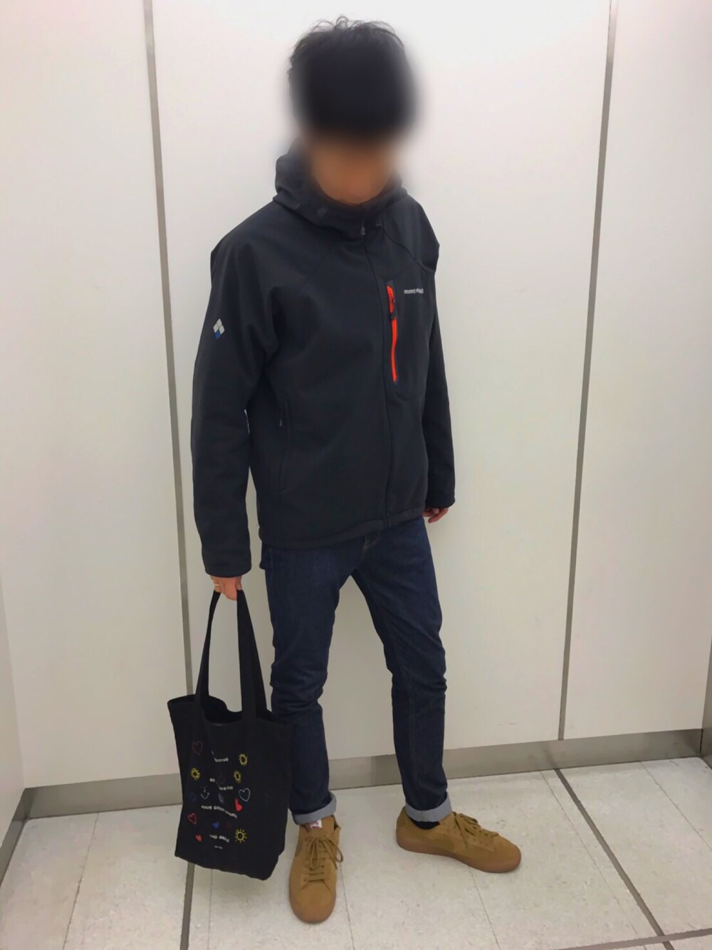 ベージュ系のスニーカー、ブルー系のデニムパンツ、ブラック系のトートバッグを着用したメンズの冬コーディネートの1枚目の写真