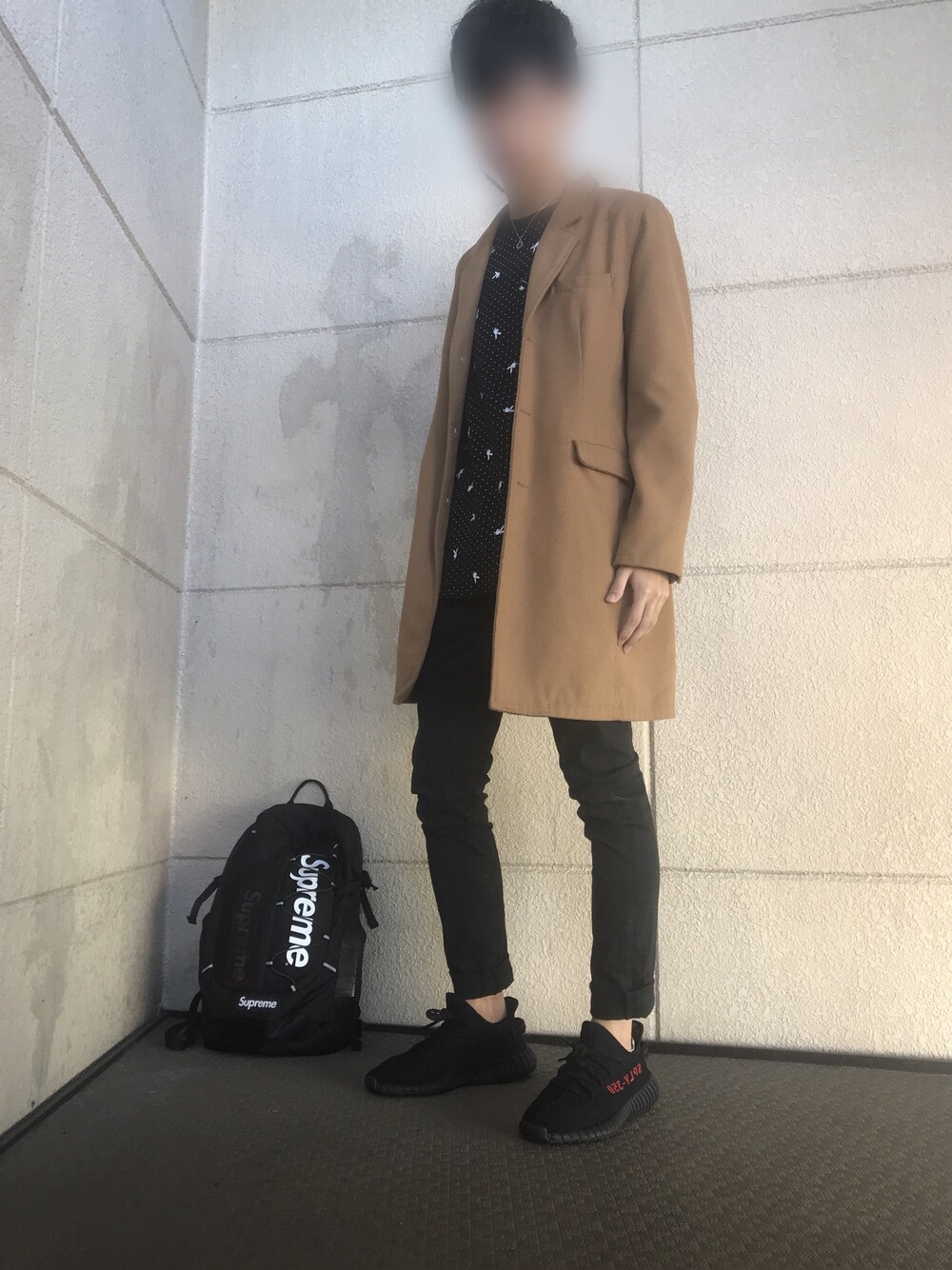 ブラック系のバックパック/リュック、ブラック系のスニーカー、ブラック系のデニムパンツを着用したメンズの秋コーディネートの1枚目の写真