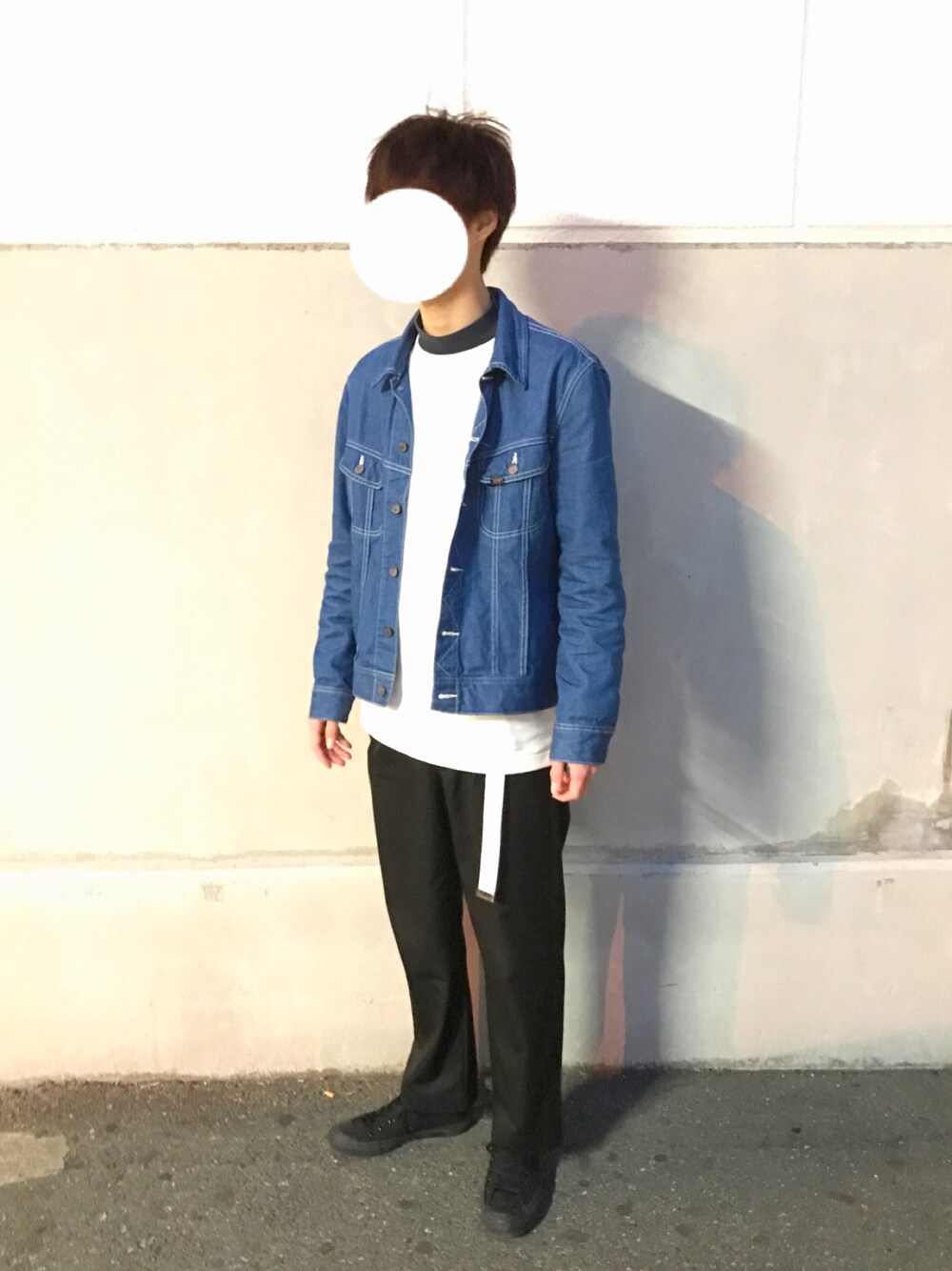 ブルー系のデニムジャケット、ブラック系のニット/セーター、ホワイト系のスウェットを着用したメンズの春コーディネートの1枚目の写真