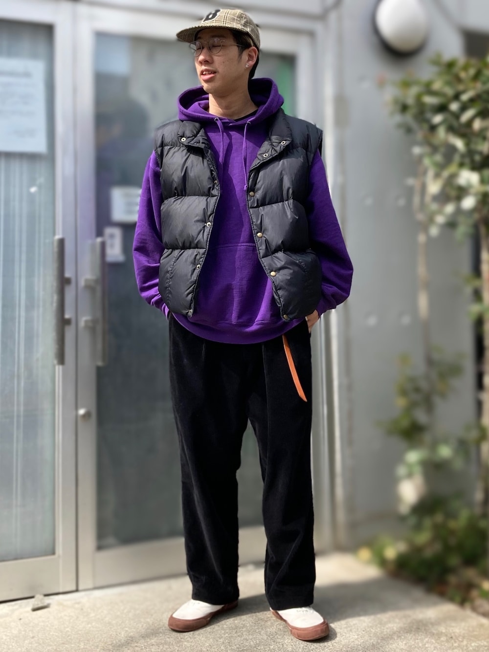 ブラック系のその他パンツ、ブラック系のダウンベスト、パープル系のパーカーを着用したメンズの春コーディネートの1枚目の写真