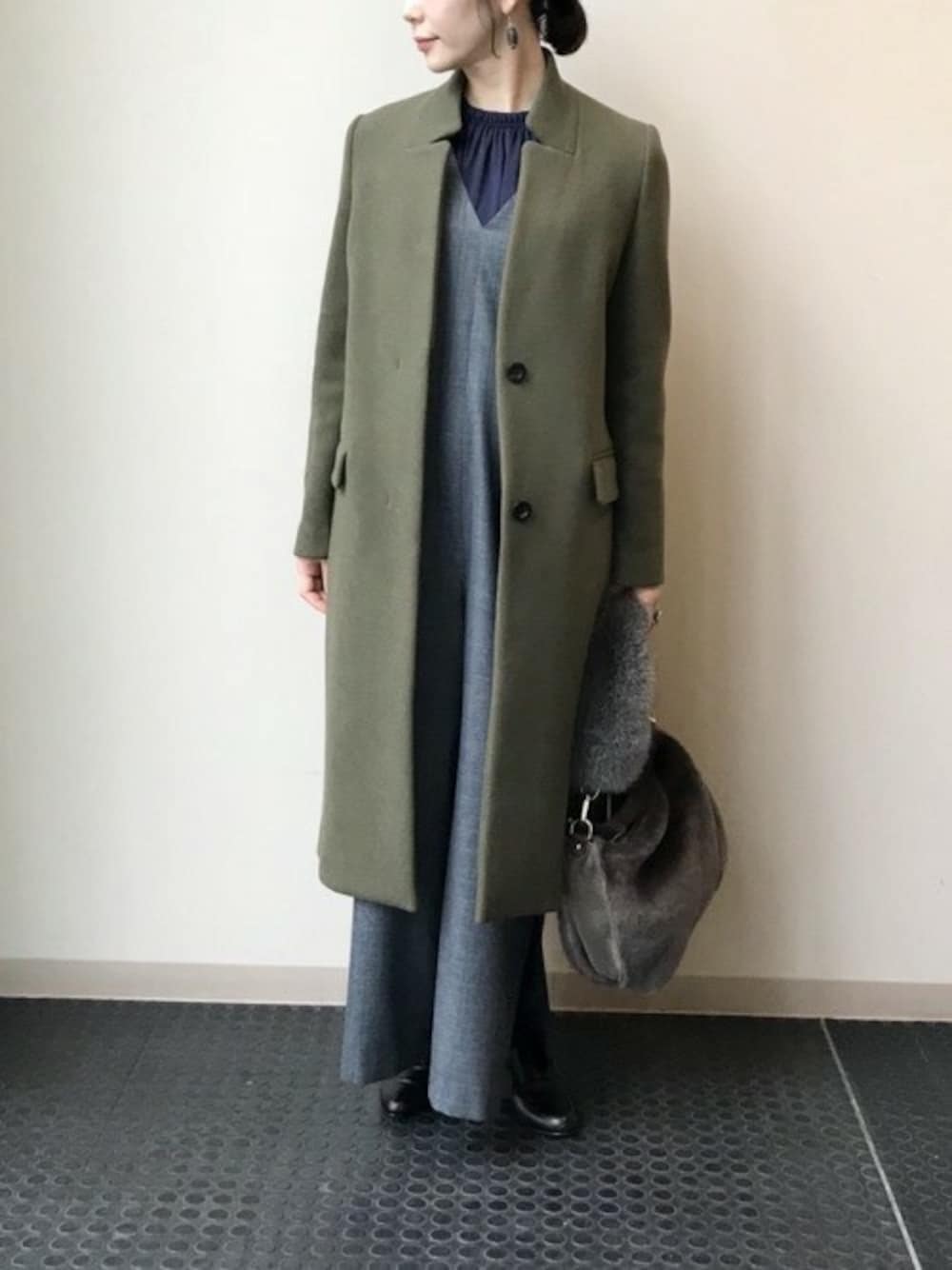 グリーン系のチェスターコート、ブルー系のシャツ/ブラウス、ブラック系のサンダルを着用したレディースの秋コーディネートの1枚目の写真