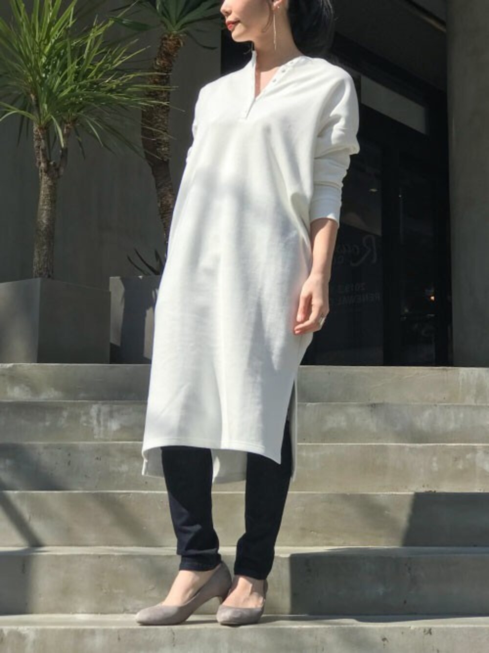 ホワイト系のワンピース、ブルー系のデニムパンツ、グレー系のパンプスを着用したレディースの春コーディネートの1枚目の写真