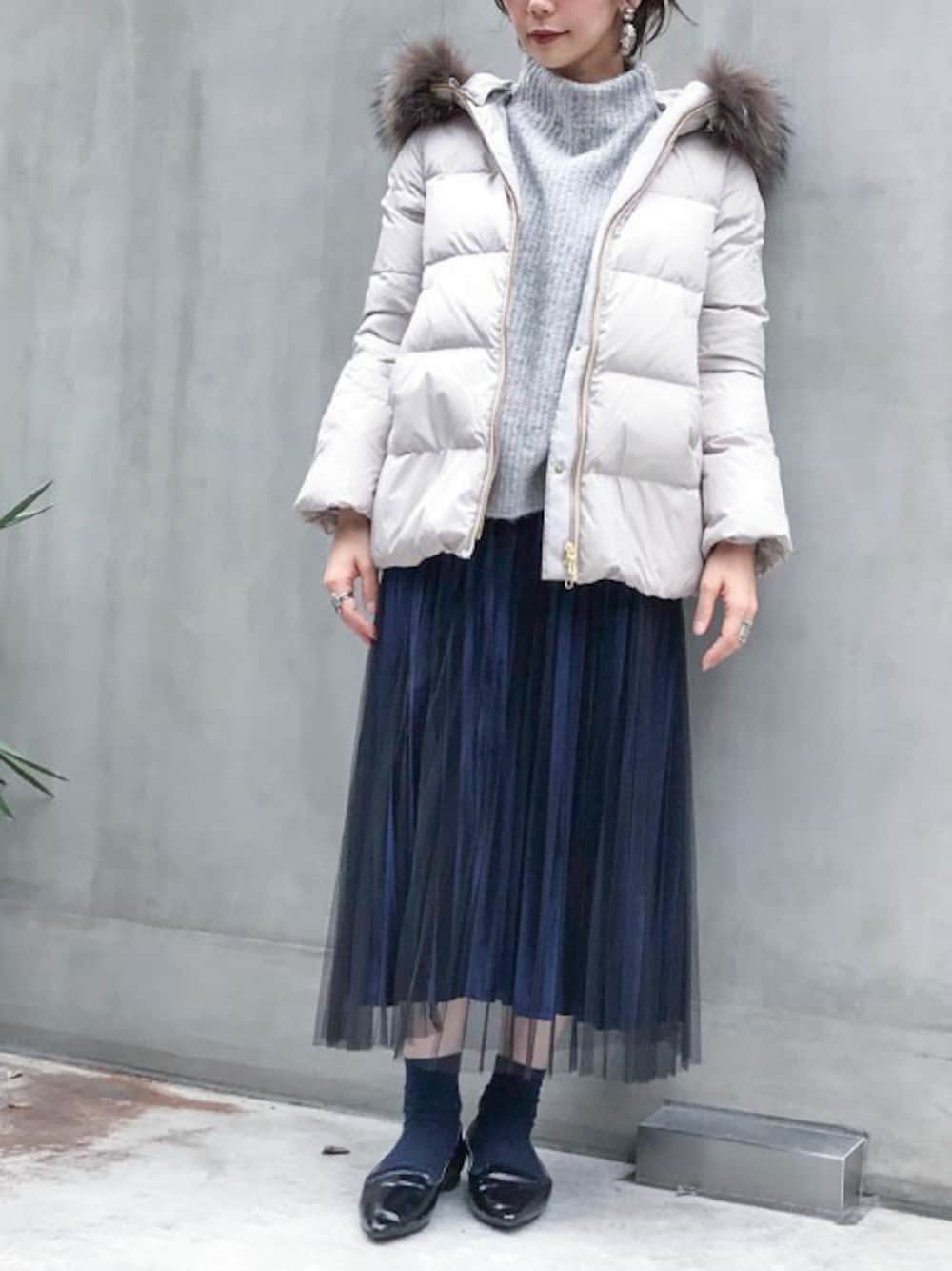 ベージュ系のダウンジャケット/コート、グレー系のニット/セーター、ブルー系のスカートを着用したレディースの秋コーディネートの1枚目の写真