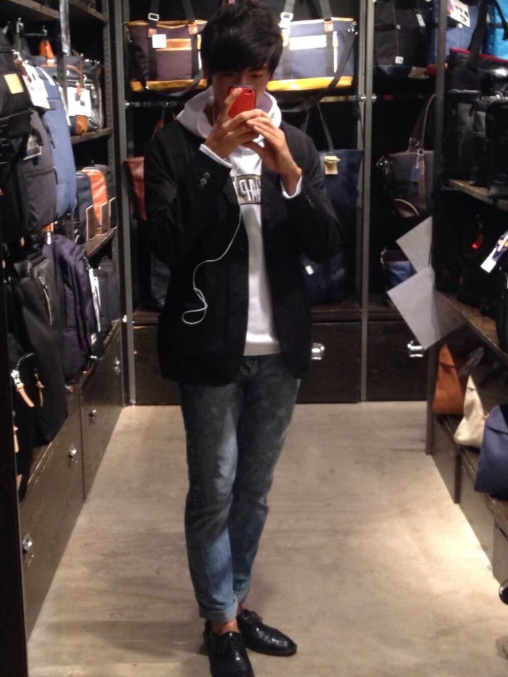 ブラック系のバックパック/リュック、ブラック系のテーラードジャケット、ブルー系のデニムパンツを着用したメンズの秋コーディネートの1枚目の写真