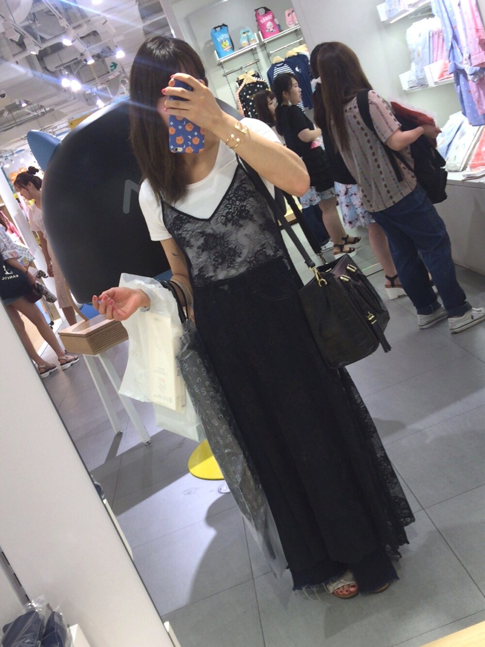 ブルー系のデニムパンツ、ブラック系のワンピース、ブラック系のトートバッグを着用したレディースの夏コーディネートの1枚目の写真