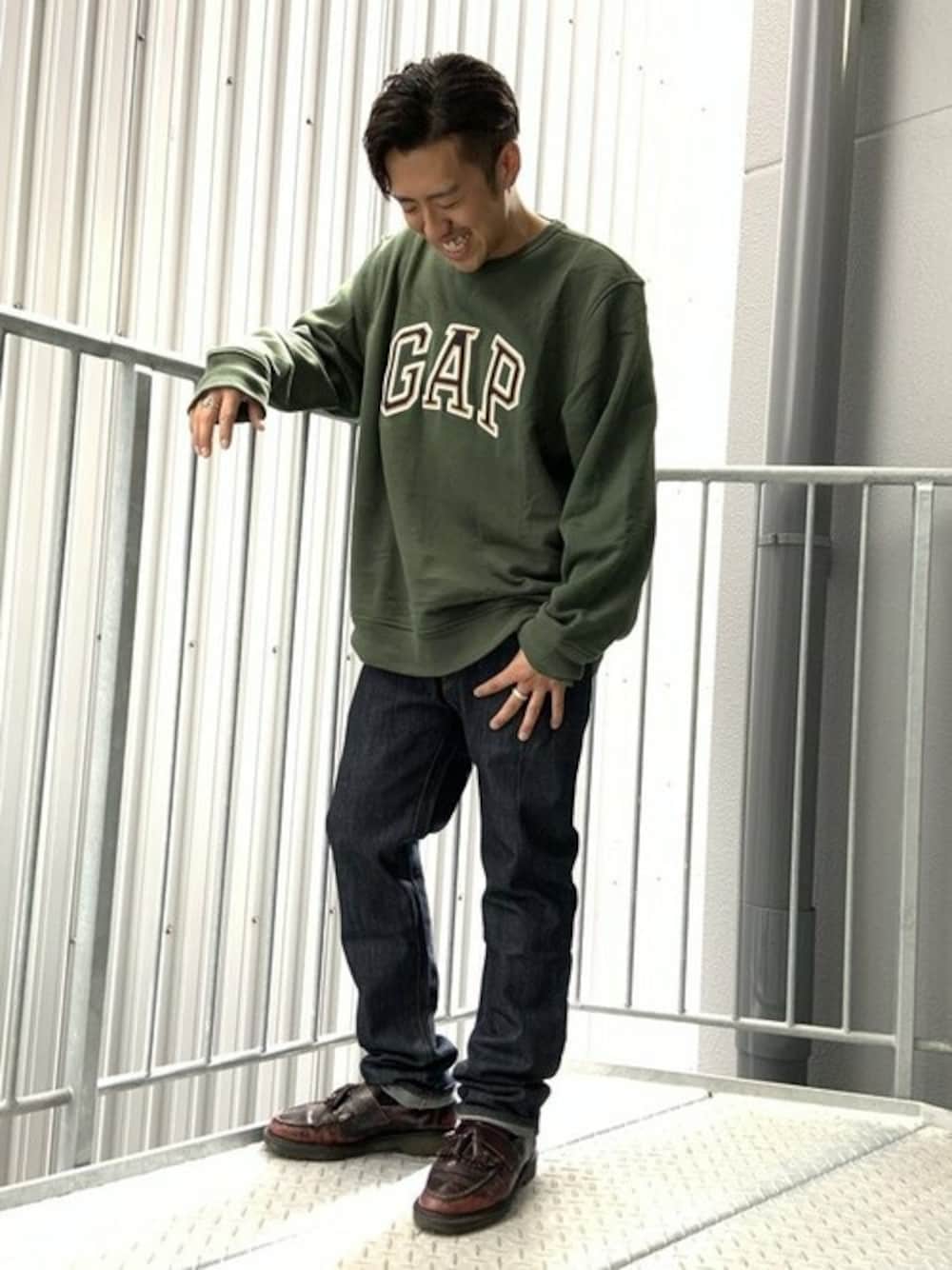 ブルー系のデニムパンツ、グリーン系のスウェットを着用したメンズの秋コーディネートの1枚目の写真