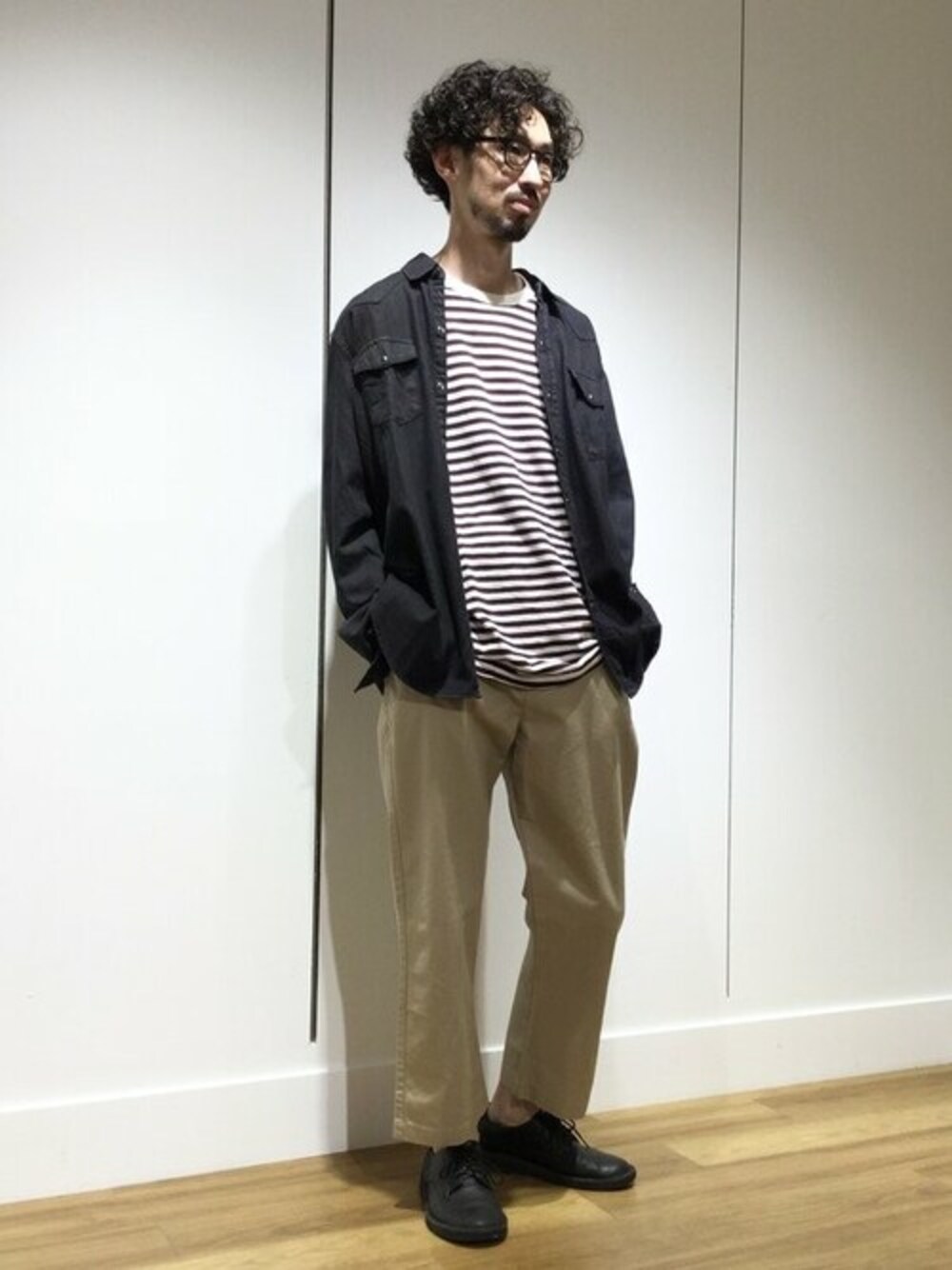 ベージュ系のチノパンツ、ブラック系のシャツ/ブラウス、ホワイト系のTシャツ/カットソーを着用したメンズの秋コーディネートの1枚目の写真