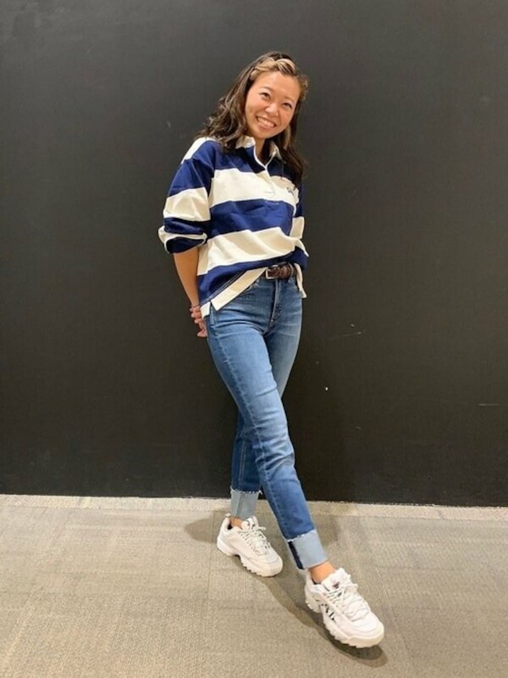 ブルー系のデニムパンツ、ホワイト系のポロシャツを着用したレディースの秋コーディネートの1枚目の写真