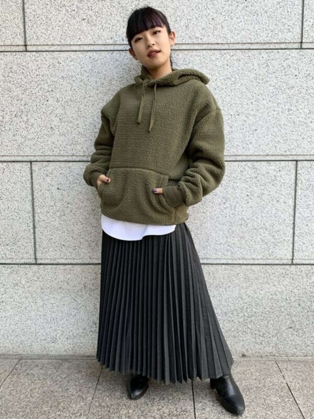 グリーン系のパーカー、グレー系のスカート、ホワイト系のTシャツ/カットソーを着用したレディースの秋コーディネートの1枚目の写真