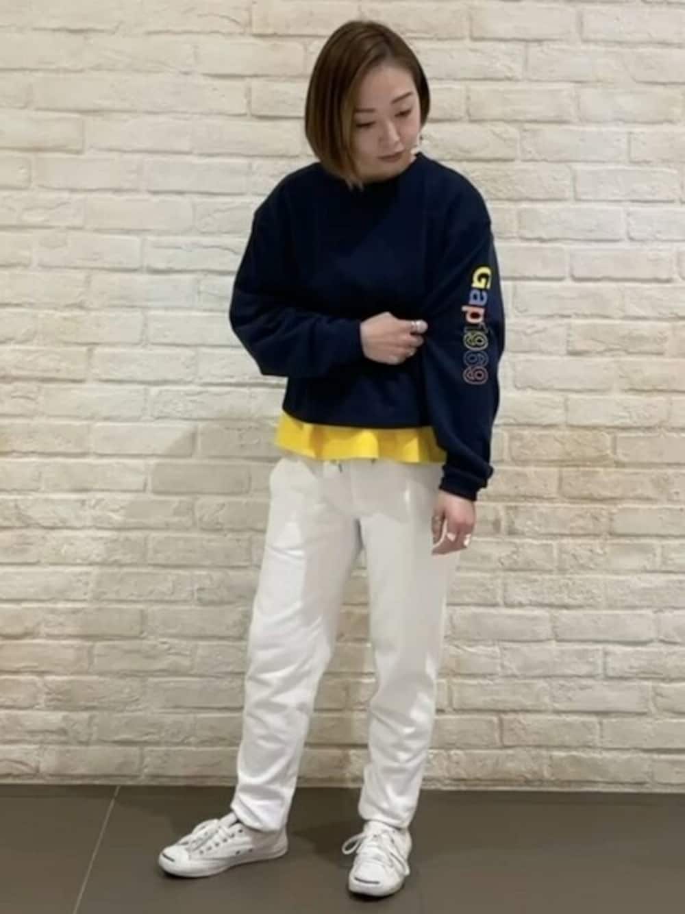 イエロー系のTシャツ/カットソー、ホワイト系のスウェットパンツ、ブルー系のスウェットを着用したレディースの冬コーディネートの1枚目の写真