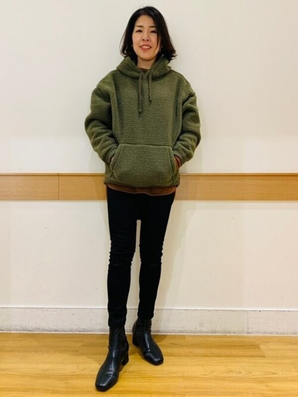 ブラウン系のTシャツ/カットソー、ブラック系のデニムパンツ、グリーン系のパーカーを着用したレディースの冬コーディネートの1枚目の写真