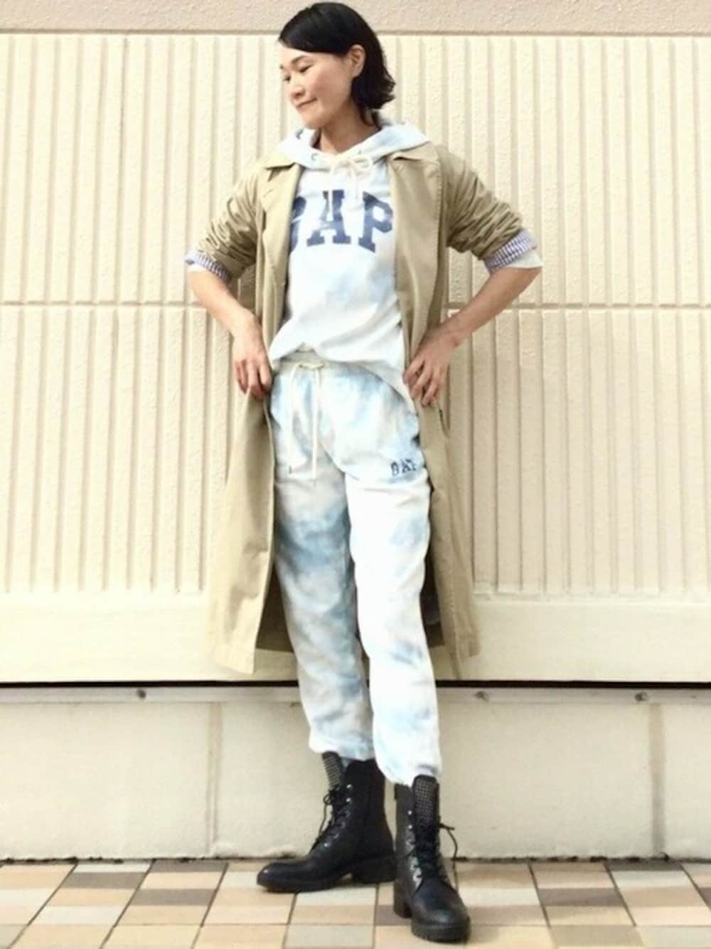 ブルー系のパーカー、ブルー系のスウェットパンツ、ベージュ系のトレンチコートを着用したレディースの冬コーディネートの1枚目の写真