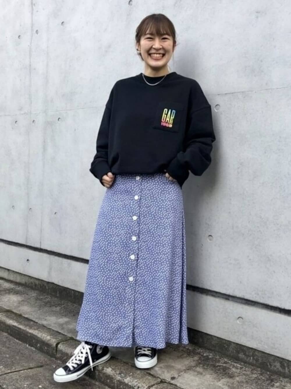 ブラック系のスウェット、ブルー系のスカートを着用したレディースの冬コーディネートの1枚目の写真