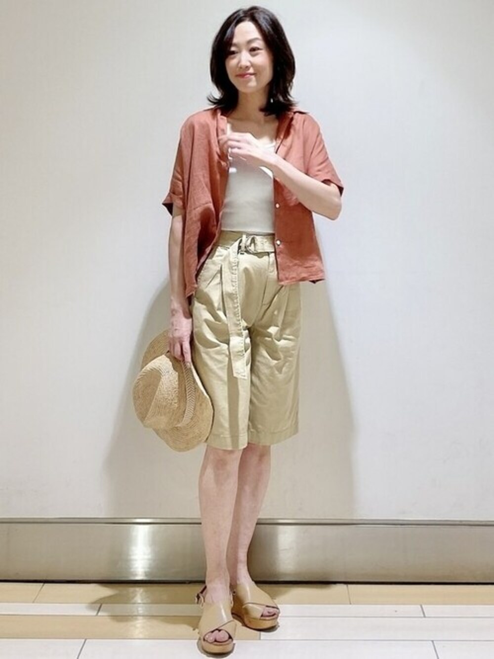 オレンジ系のシャツ/ブラウス、ホワイト系のタンクトップ、ベージュ系のその他パンツを着用したレディースの春コーディネートの1枚目の写真