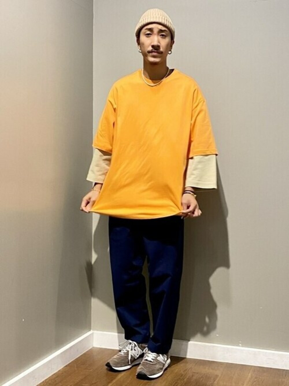 オレンジ系のTシャツ/カットソー、ブルー系のチノパンツを着用したメンズの夏コーディネートの1枚目の写真