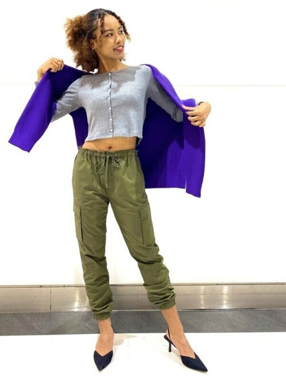 グレー系のTシャツ/カットソー、ブラック系のカーゴパンツ、パープル系のニット/セーターを着用したレディースの秋コーディネートの1枚目の写真