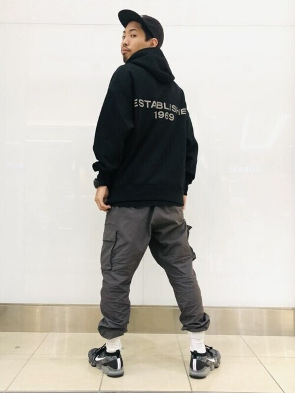 ブラック系のパーカー、ブラック系のカーゴパンツを着用したメンズの秋コーディネートの1枚目の写真