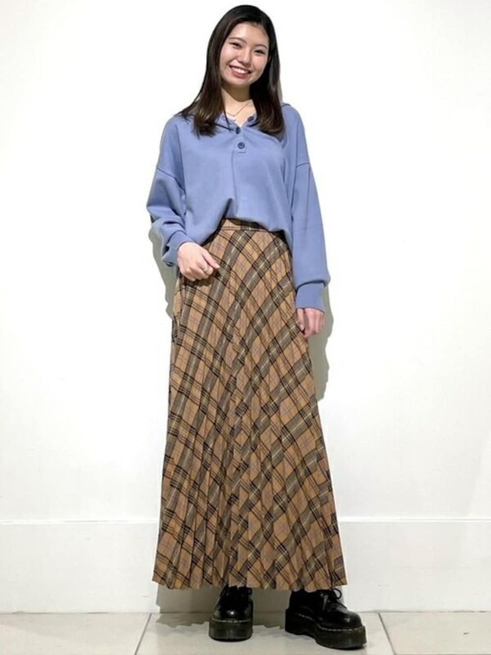 グレー系のパーカー、ブラウン系のスカートを着用したレディースの秋コーディネートの1枚目の写真