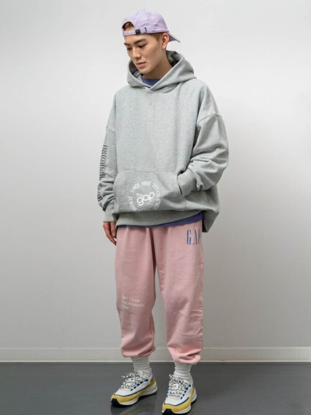 グレー系のパーカー、パープル系のTシャツ/カットソー、ピンク系のスウェットパンツを着用したメンズの冬コーディネートの1枚目の写真