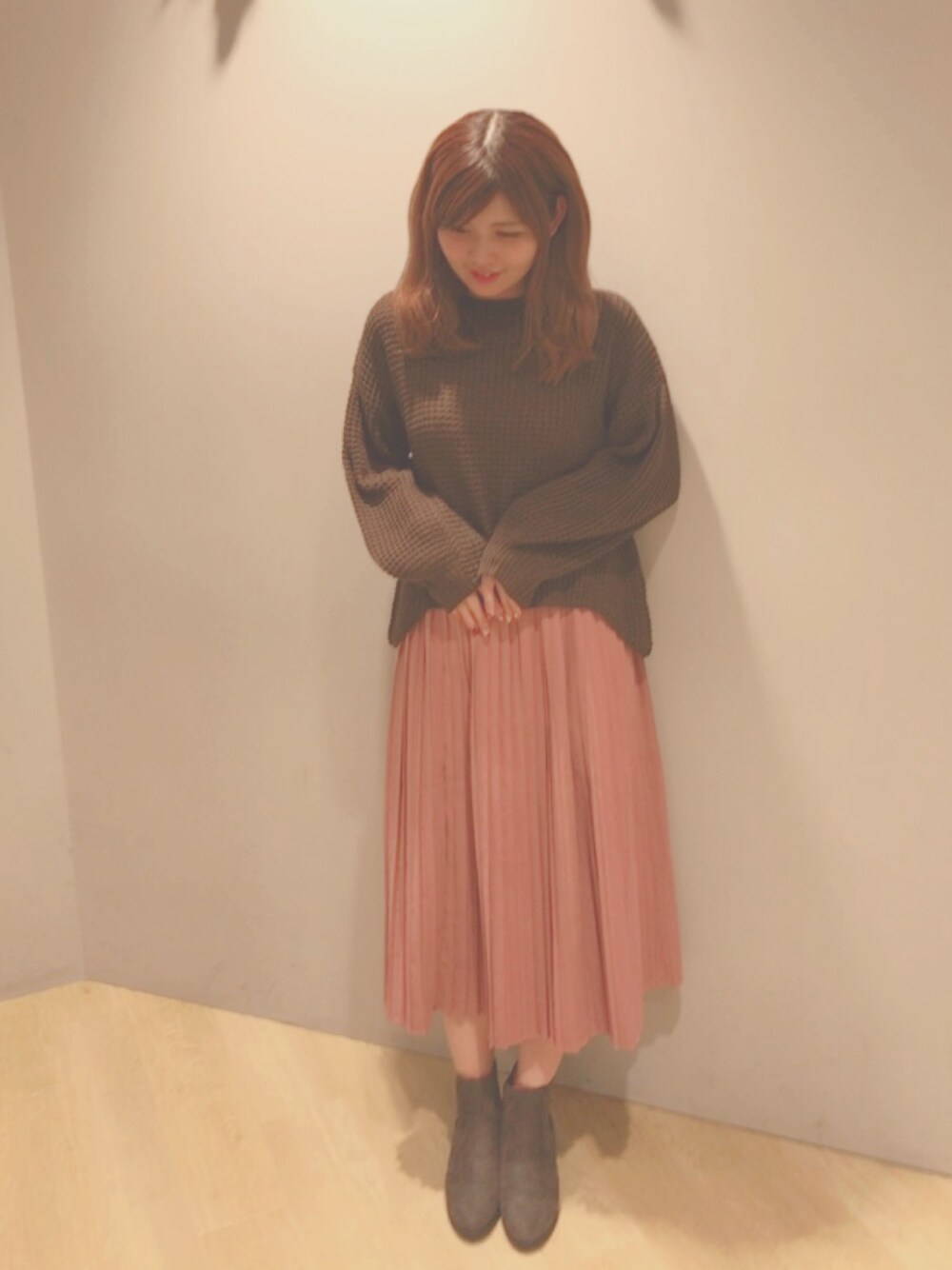 ブラウン系のニット/セーター、ピンク系のスカート、グレー系のブーツを着用したレディースの秋コーディネートの1枚目の写真