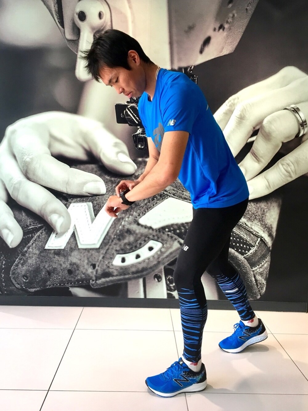 「スニーカー、ロゴT、ブルー、New Balance、Tシャツ、ニューバランス、タイツ、時計、ランニングスタイル、ランニングシューズ」｜「NEW BALANCEのアクセレレイトショートスリーブグラフィックTシャツ （Tシャツ/カットソー、ブルー系）」を使った、NEWBALANCEAOYAMAさん（メンズ・175cm）の春コーディネートの1枚目の写真