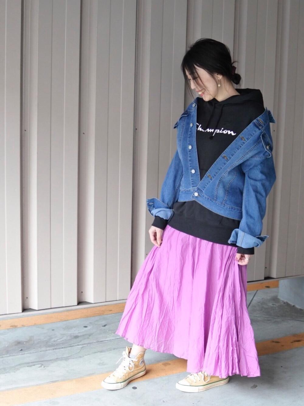 ブラック系のパーカー、パープル系のスカート、ブルー系のデニムジャケットを着用したレディースの冬コーディネートの1枚目の写真