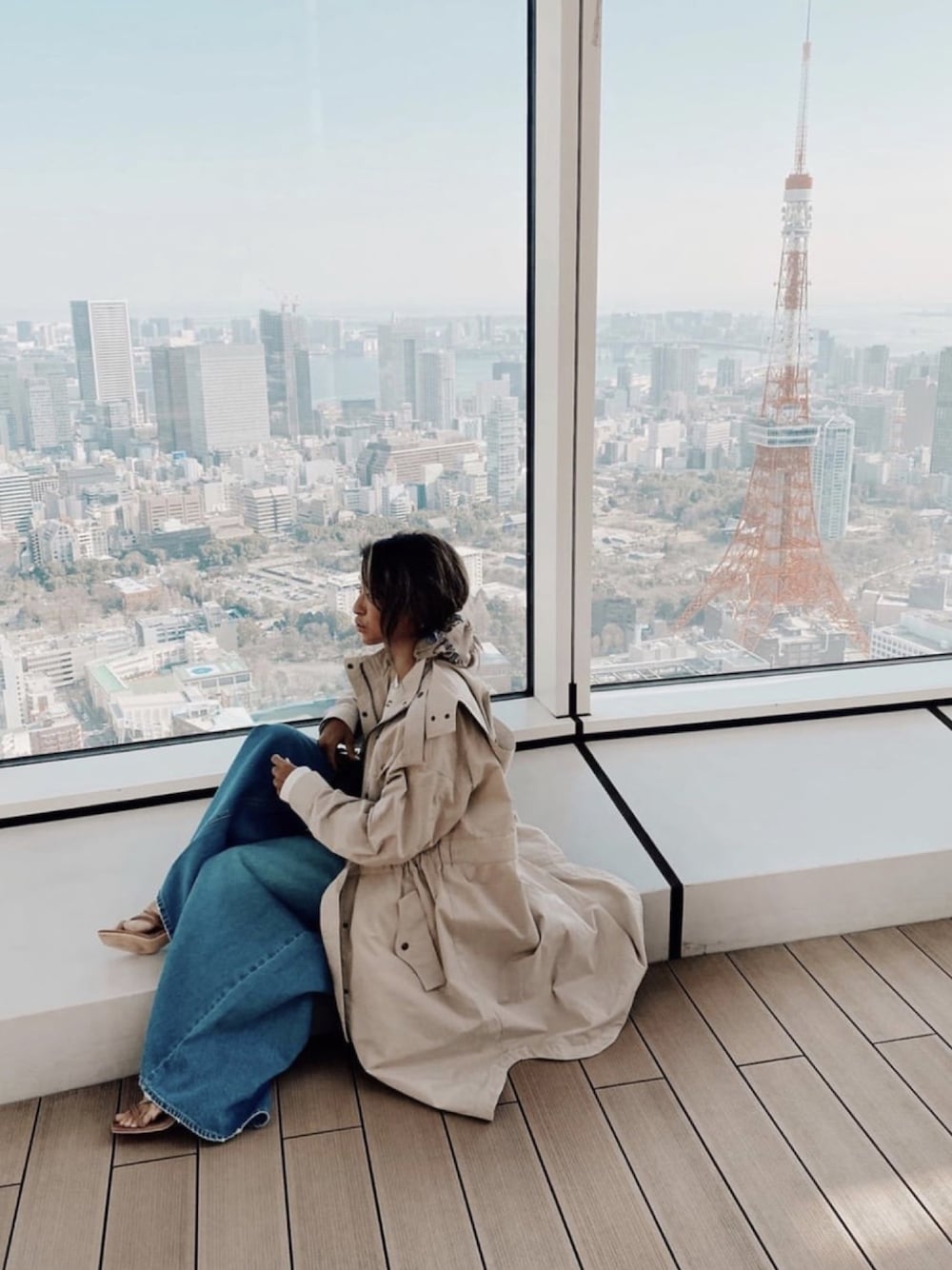 ベージュ系のミリタリージャケット、ブルー系のデニムパンツ、ブラウン系のサンダルを着用したレディースの春コーディネートの1枚目の写真