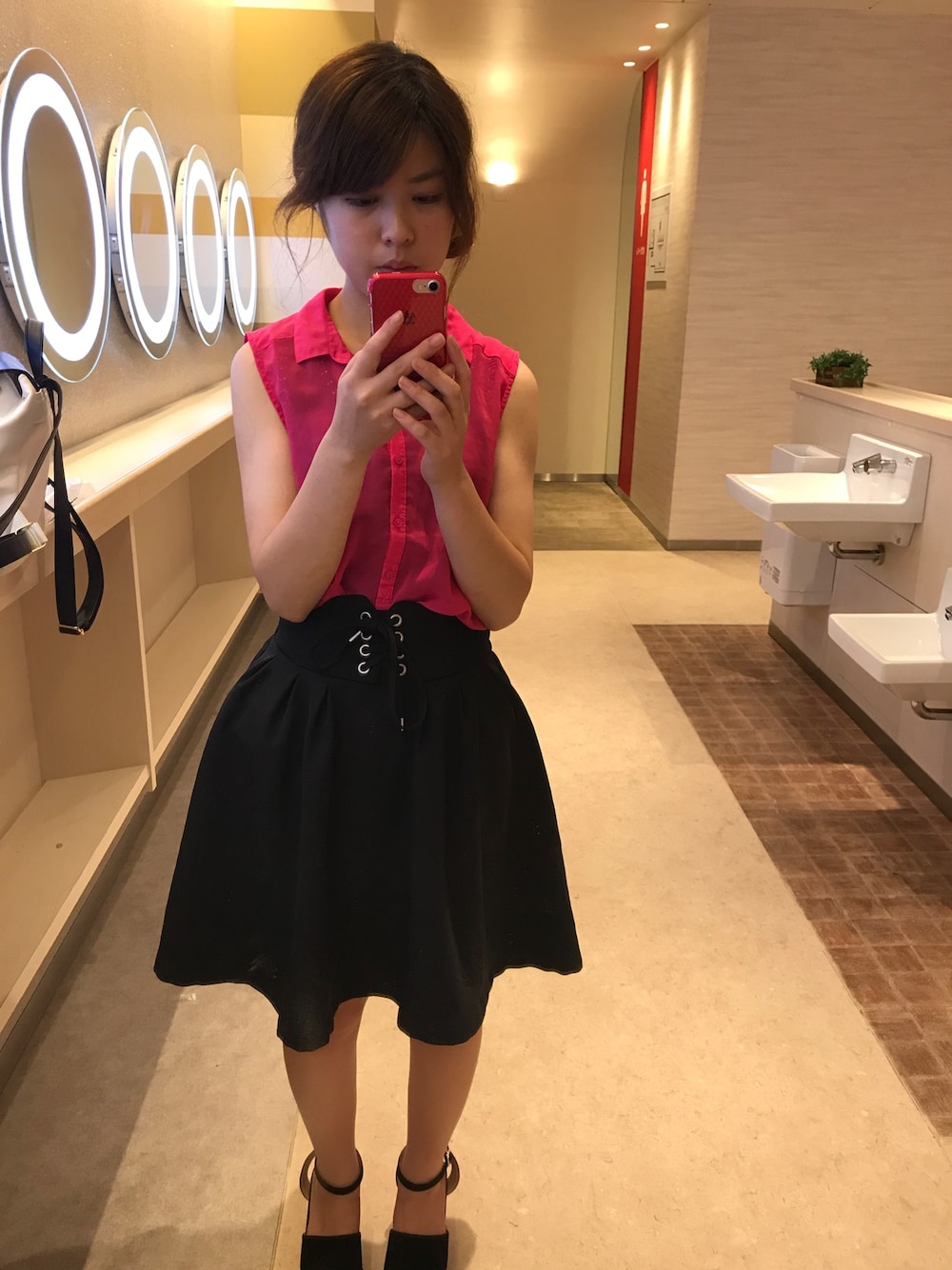 ブラック系のスカート、ピンク系のシャツ/ブラウス、ブラック系のサンダルを着用したレディースの夏コーディネートの1枚目の写真