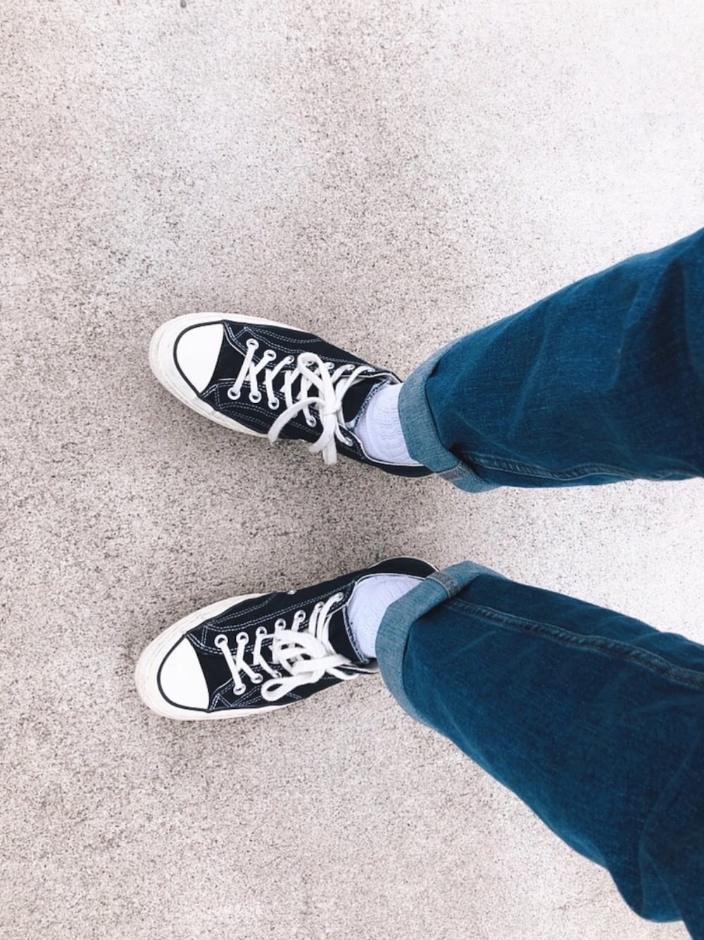 ブルー系のデニムパンツ、ブラック系のスニーカーを着用したメンズの春コーディネートの1枚目の写真