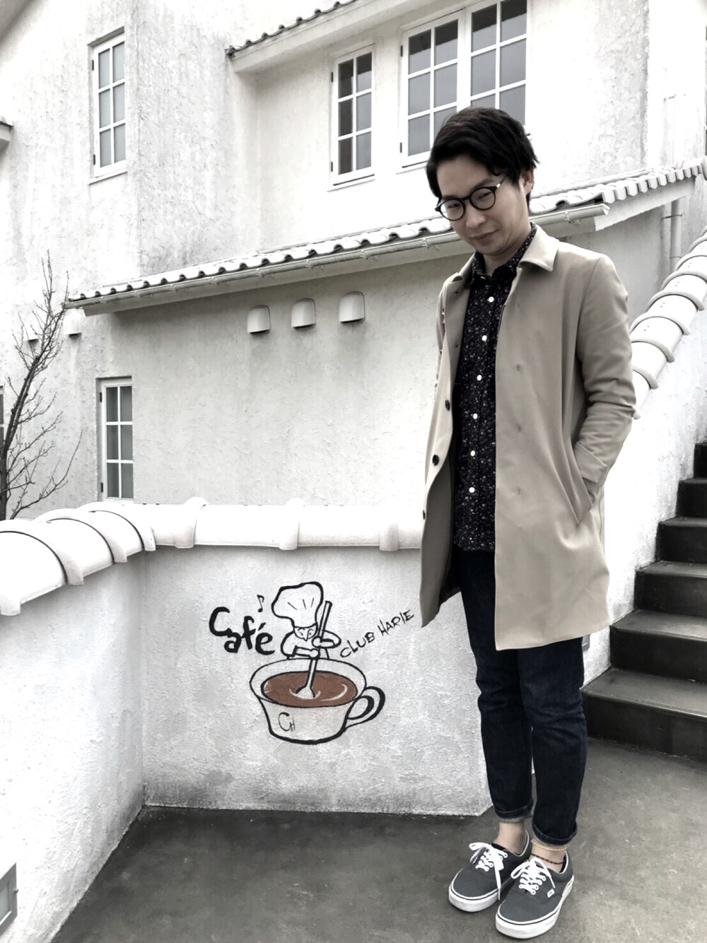 「大人カジュアル、めがね、ステンカラーコート、花柄、デニム、スニーカー、バンズ、カフェ」｜「STUDIOUSのSTUDIOUS ハイストレッチスプリングステンカラーコート（ステンカラーコート、ベージュ系）」を使った、シリウスさん（メンズ・168cm）の春コーディネートの1枚目の写真