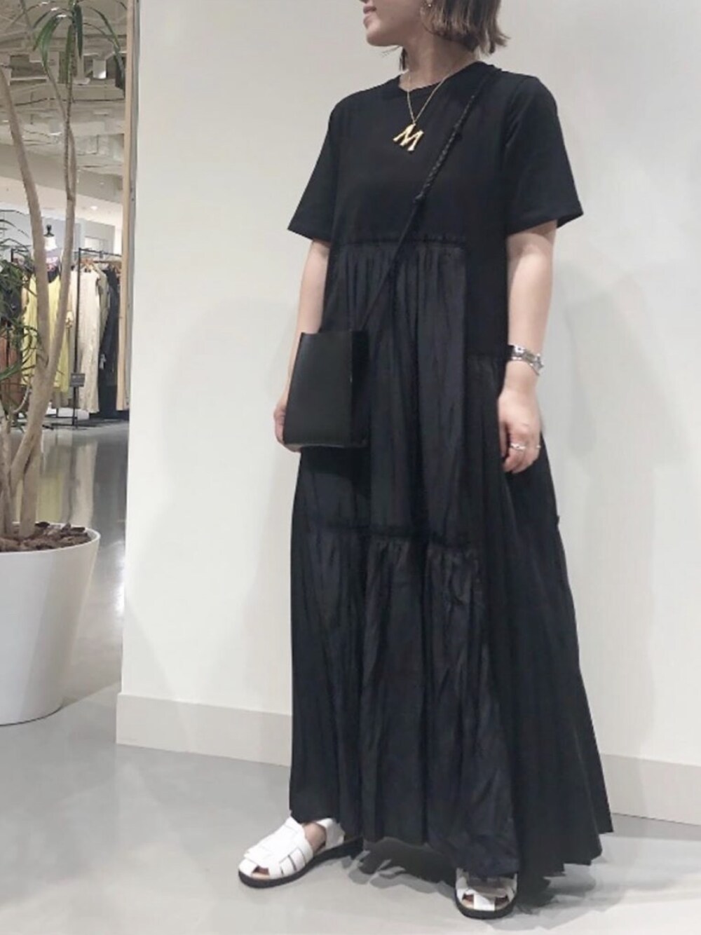 ブラック系のワンピース、ホワイト系のサンダル、シルバー系のバングル/リストバンドを着用したレディースの夏コーディネートの1枚目の写真